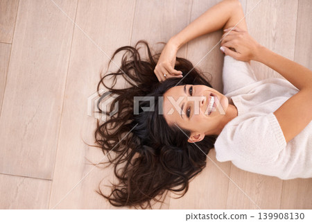 Woman, portrait and happiness on floor for relax with top view, weekend break and confidence in apartment. Person, lying down and face with laughing in home on wooden flooring for fun and freedom Woman, portrait and happiness on floor for relax with top view, weekend break and confidence in apartment. Person, lying down and face with laughing in home on wooden flooring for fun and freedom 139908130