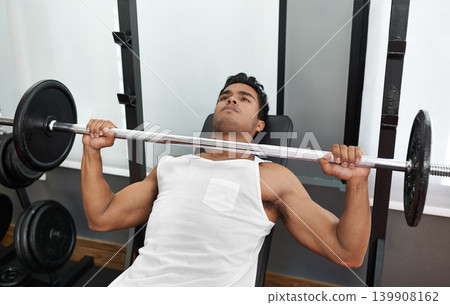 Bench, press and man at gym for exercise, workout and body building in Mexico. Healthy, person and weightlifting challenge for strong muscle, fitness or progress in training arms with barbell in club Bench, press and man at gym for exercise, workout and body building in Mexico. Healthy, person and weightlifting challenge for strong muscle, fitness or progress in training arms with barbell in club 139908162