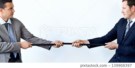 Businessman, rope and tug of war for challenge, mission or strength of rivals on a blue studio background. Man, business employees or colleagues hands pulling strong cable for competition on mockup Businessman, rope and tug of war for challenge, mission or strength of rivals on a blue studio background. Man, business employees or colleagues hands pulling strong cable for competition on mockup 139908397