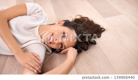Woman, portrait and smile on floor for relax with pride, weekend break or confidence in apartment. Person, lying down and face with happiness in home on wooden flooring for fun, freedom or leisure 139908440