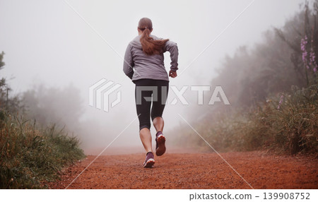 Woman, rear view and running in woods with fitness for exercise, morning routine and workout with fog and legs. Athlete, person and cardio with sportswear on outdoor trail and forest for wellness Woman, rear view and running in woods with fitness for exercise, morning routine and workout with fog and legs. Athlete, person and cardio with sportswear on outdoor trail and forest for wellness 139908752