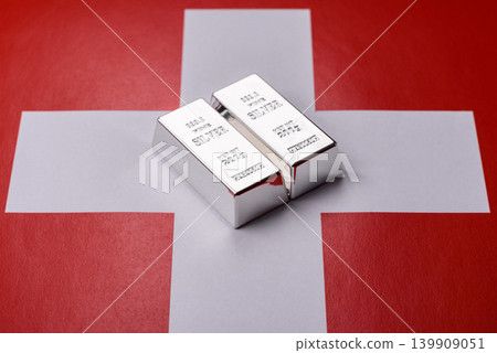 A silver bar, white metal against a backdrop of Swiss flag, as a concept for the sales. A silver bar A silver bar, white metal against a backdrop of Swiss flag, as a concept for the sales. A silver bar 139909051