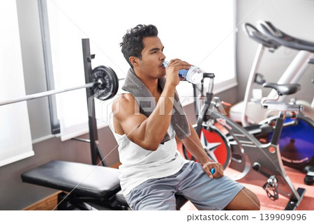Gym, fitness and man drinking water for training, wellness or exercise recovery, break or resting. Workout, hydration and thirsty male athlete with sports drink after intense, cardio or bodybuilding Gym, fitness and man drinking water for training, wellness or exercise recovery, break or resting. Workout, hydration and thirsty male athlete with sports drink after intense, cardio or bodybuilding 139909096