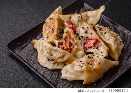 Gyoza, Chinese or Japanese meat dumplings, is an Asian food with hot peppers. Gyoza with meat 139909154