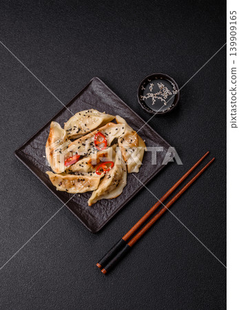 Gyoza, Chinese or Japanese meat dumplings, is an Asian food with hot peppers. Gyoza with meat Gyoza, Chinese or Japanese meat dumplings, is an Asian food with hot peppers. Gyoza with meat 139909165