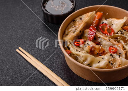 Gyoza, Chinese or Japanese meat dumplings, is an Asian food with hot peppers. Gyoza with meat Gyoza, Chinese or Japanese meat dumplings, is an Asian food with hot peppers. Gyoza with meat 139909171