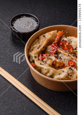 Gyoza, Chinese or Japanese meat dumplings, is an Asian food with hot peppers. Gyoza with meat Gyoza, Chinese or Japanese meat dumplings, is an Asian food with hot peppers. Gyoza with meat 139909174