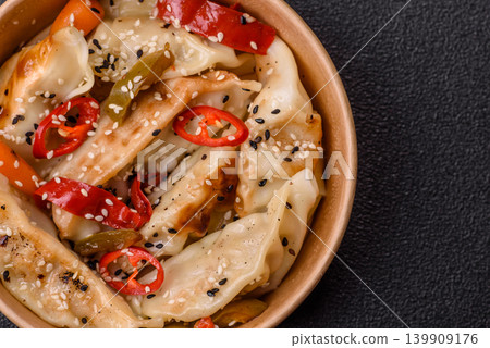 Gyoza, Chinese or Japanese meat dumplings, is an Asian food with hot peppers. Gyoza with meat Gyoza, Chinese or Japanese meat dumplings, is an Asian food with hot peppers. Gyoza with meat 139909176