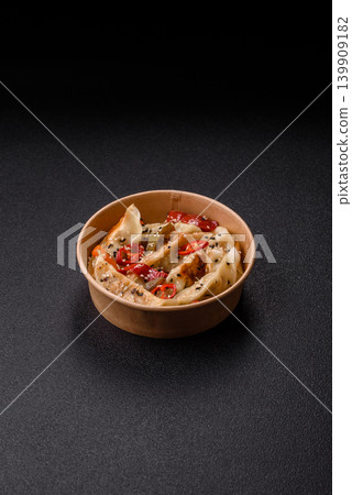 Gyoza, Chinese or Japanese meat dumplings, is an Asian food with hot peppers. Gyoza with meat Gyoza, Chinese or Japanese meat dumplings, is an Asian food with hot peppers. Gyoza with meat 139909182