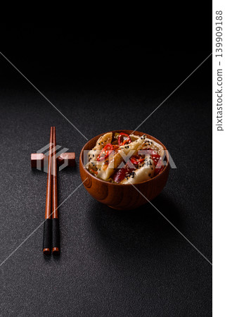 Gyoza, Chinese or Japanese meat dumplings, is an Asian food with hot peppers. Gyoza with meat Gyoza, Chinese or Japanese meat dumplings, is an Asian food with hot peppers. Gyoza with meat 139909188