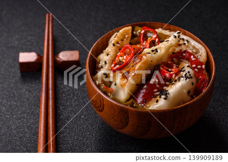 Gyoza, Chinese or Japanese meat dumplings, is an Asian food with hot peppers. Gyoza with meat Gyoza, Chinese or Japanese meat dumplings, is an Asian food with hot peppers. Gyoza with meat 139909189
