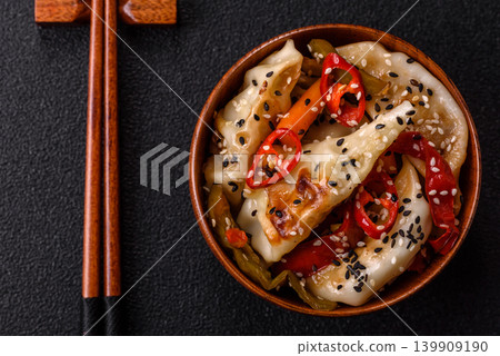 Gyoza, Chinese or Japanese meat dumplings, is an Asian food with hot peppers. Gyoza with meat Gyoza, Chinese or Japanese meat dumplings, is an Asian food with hot peppers. Gyoza with meat 139909190