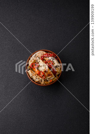 Gyoza, Chinese or Japanese meat dumplings, is an Asian food with hot peppers. Gyoza with meat Gyoza, Chinese or Japanese meat dumplings, is an Asian food with hot peppers. Gyoza with meat 139909199