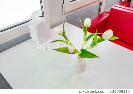 flowers in a vase on a table in a cafe 139909313