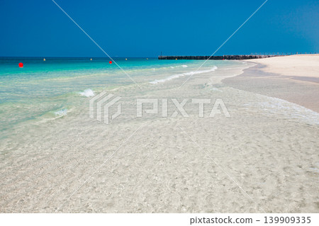 surf on sandy beach and buoys on water in sea 139909335