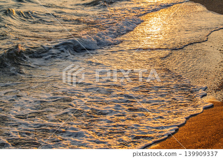 sea surf with foam on the beach at sunset, close-up sea surf with foam on the beach at sunset, close-up 139909337