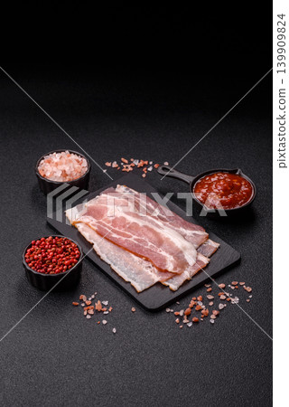 Raw fresh bacon slices with layers of meat or prosciutto with salt and spices. Raw bacon Raw fresh bacon slices with layers of meat or prosciutto with salt and spices. Raw bacon 139909824