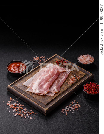 Raw fresh bacon slices with layers of meat or prosciutto with salt and spices. Raw bacon Raw fresh bacon slices with layers of meat or prosciutto with salt and spices. Raw bacon 139909827