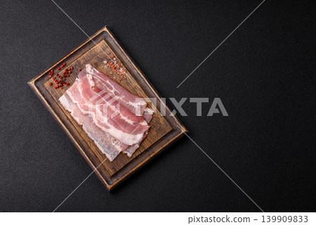 Raw fresh bacon slices with layers of meat or prosciutto with salt and spices. Raw bacon Raw fresh bacon slices with layers of meat or prosciutto with salt and spices. Raw bacon 139909833