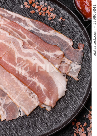 Raw fresh bacon slices with layers of meat or prosciutto with salt and spices. Raw bacon Raw fresh bacon slices with layers of meat or prosciutto with salt and spices. Raw bacon 139909841