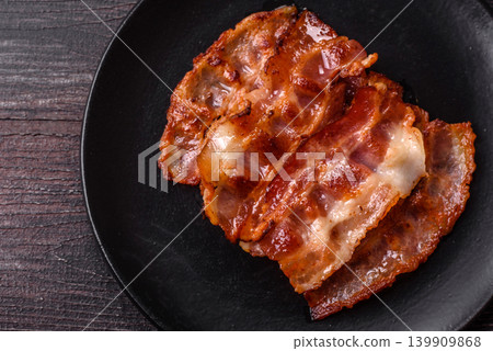 Fried fresh bacon slices with layers of meat or prosciutto with salt and spices. Fried bacon Fried fresh bacon slices with layers of meat or prosciutto with salt and spices. Fried bacon 139909868