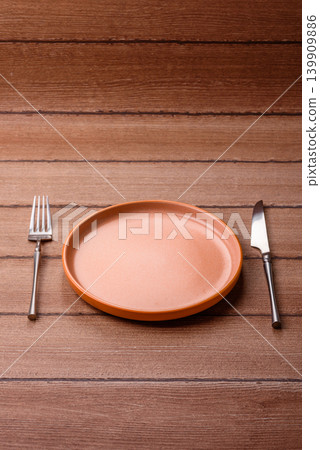 An empty ceramic round plate, kitchen utensils for a dinner table. An empty plate 139909886