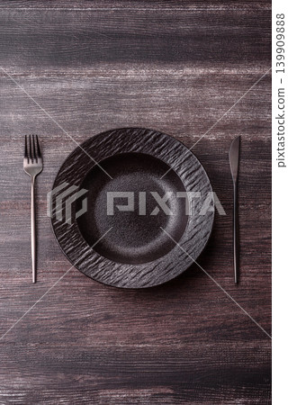 An empty ceramic round plate, kitchen utensils for a dinner table. An empty plate An empty ceramic round plate, kitchen utensils for a dinner table. An empty plate 139909888