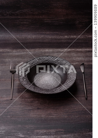 An empty ceramic round plate, kitchen utensils for a dinner table. An empty plate An empty ceramic round plate, kitchen utensils for a dinner table. An empty plate 139909889