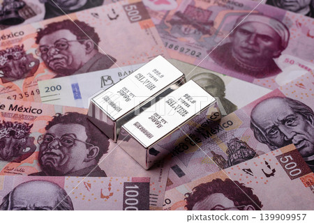 A silver bar, white metal against a backdrop of Mexican money, concept for the sales market A silver bar, white metal against a backdrop of Mexican money, concept for the sales market 139909957