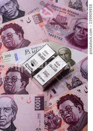 A silver bar, white metal against a backdrop of Mexican money, concept for the sales market A silver bar, white metal against a backdrop of Mexican money, concept for the sales market 139909958
