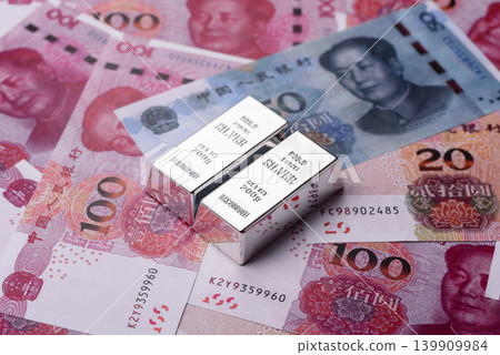 A silver bar, white metal against a backdrop of Chinese money, as a concept for the sales market A silver bar, white metal against a backdrop of Chinese money, as a concept for the sales market 139909984