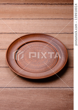An empty ceramic round plate, kitchen utensils for a dinner table. An empty plate 139910014