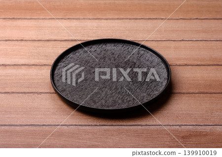 An empty ceramic round plate, kitchen utensils for a dinner table. An empty plate An empty ceramic round plate, kitchen utensils for a dinner table. An empty plate 139910019