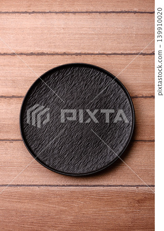 An empty ceramic round plate, kitchen utensils for a dinner table. An empty plate An empty ceramic round plate, kitchen utensils for a dinner table. An empty plate 139910020
