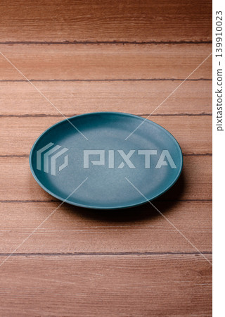 An empty ceramic round plate, kitchen utensils for a dinner table. An empty plate An empty ceramic round plate, kitchen utensils for a dinner table. An empty plate 139910023