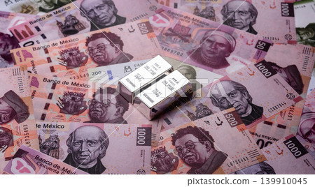 A silver bar, white metal against a backdrop of Mexican money, concept for the sales market A silver bar, white metal against a backdrop of Mexican money, concept for the sales market 139910045