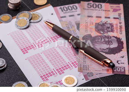 Lottery ticket, Mexican banknotes, and a pen, chance to win big, gambling. Lottery ticket 139910098