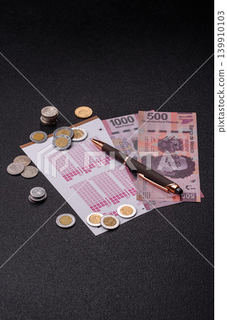 Lottery ticket, Mexican banknotes, and a pen, chance to win big, gambling. Lottery ticket 139910103