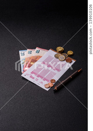 Lottery ticket, banknotes, and a pen, a chance to win big, gambling. Lottery ticket Lottery ticket, banknotes, and a pen, a chance to win big, gambling. Lottery ticket 139910106