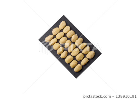 Raw homemade potato gnocchi, made with salt and spices, ready for lunch. Raw gnocchi 139910191