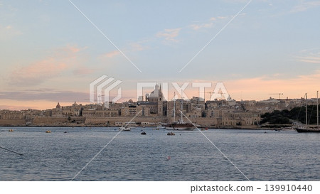 View of Valletta behind various boats sailing in the evening View of Valletta behind various boats sailing in the evening 139910440