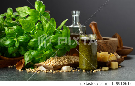 Pesto sauce and ingredients on a black stone table. Pesto sauce and ingredients on a black stone table. 139910612