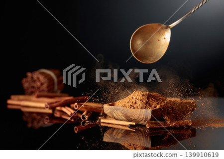 Cinnamon powder is poured into a wooden dish. Cinnamon powder is poured into a wooden dish. 139910619