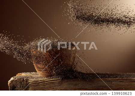 Chia seeds is poured into a wooden bowl. Chia seeds is poured into a wooden bowl. 139910623