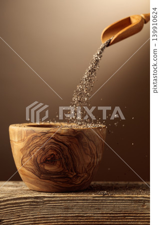 Chia seeds is poured into a wooden bowl. Chia seeds is poured into a wooden bowl. 139910624