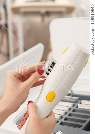 Close-up of a cosmetologist changing a cartridge on a modern laser handpiece 139910649