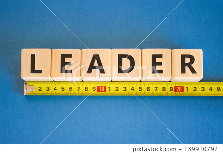 Leadership and leader symbol. Concept word Leader on beautiful wooden blocks. Beautiful blue background. Beautiful yellow tape measure ruler. Business leader and leadership concept. Copy space. Leadership and leader symbol. Concept word Leader on beautiful wooden blocks. Beautiful blue background. Beautiful yellow tape measure ruler. Business leader and leadership concept. Copy space. 139910792