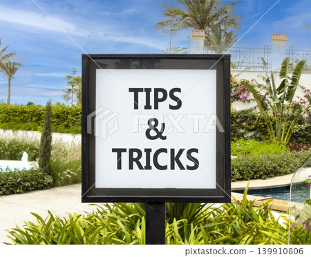Tips and tricks words symbol. Concept words Tips and tricks on beautiful white sign. Beautiful hotel garden blue sky background. Business tips and tricks motivational support concept. Copy space. Tips and tricks words symbol. Concept words Tips and tricks on beautiful white sign. Beautiful hotel garden blue sky background. Business tips and tricks motivational support concept. Copy space. 139910806