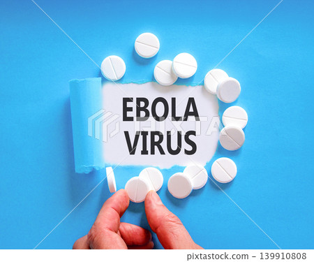 Ebola virus medical words symbol. Concept words Ebola virus on beautiful white paper. Beautiful blue background. Doctor hand. Beautiful white pills. Medical Ebola virus concept. Copy space. Ebola virus medical words symbol. Concept words Ebola virus on beautiful white paper. Beautiful blue background. Doctor hand. Beautiful white pills. Medical Ebola virus concept. Copy space. 139910808