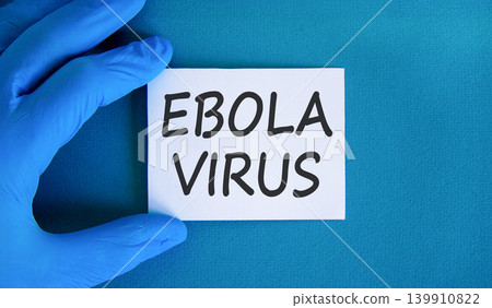 Ebola virus medical words symbol. Concept words Ebola virus on beautiful white paper. Beautiful blue background. Doctor hand. Medical Ebola virus concept. Copy space. Ebola virus medical words symbol. Concept words Ebola virus on beautiful white paper. Beautiful blue background. Doctor hand. Medical Ebola virus concept. Copy space. 139910822